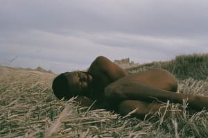 Photograph of JJJJJerome Ellis lying naked in a field.