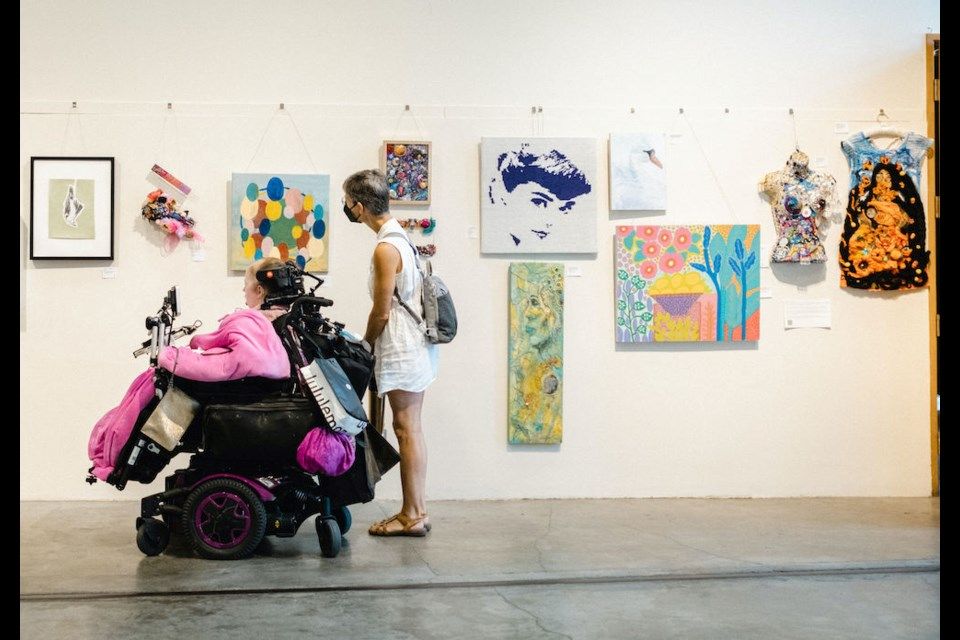 Person in wheelchair viewing art on gallery wall